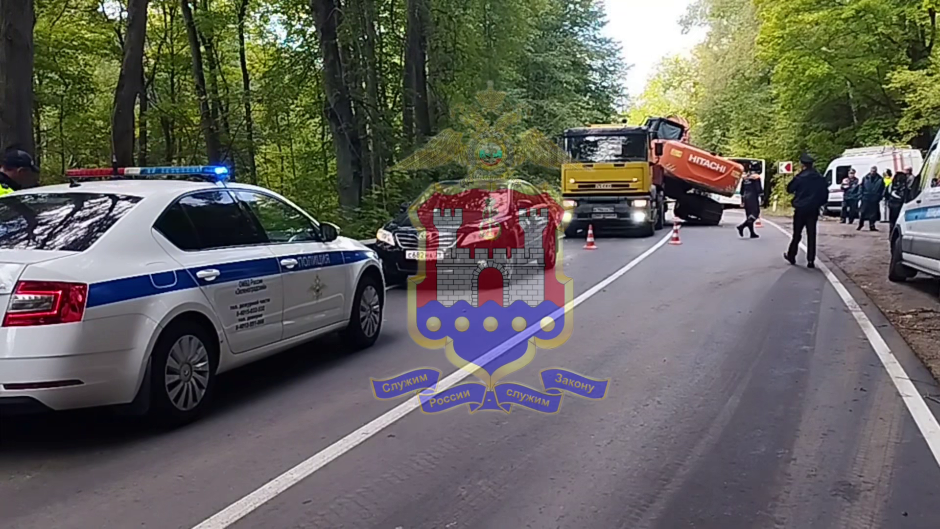 Калининградские полицейские работают на месте ДТП, где скатившийся с трала экскаватор упал на автобус